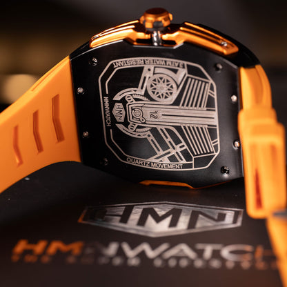 Close-up of a HMN watch with orange strap and black face displaying intricate design.
