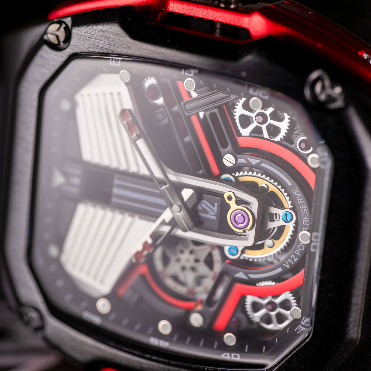 Close-up of a HMN V12 Cullinan mechanical watch with intricate gears and red accents.